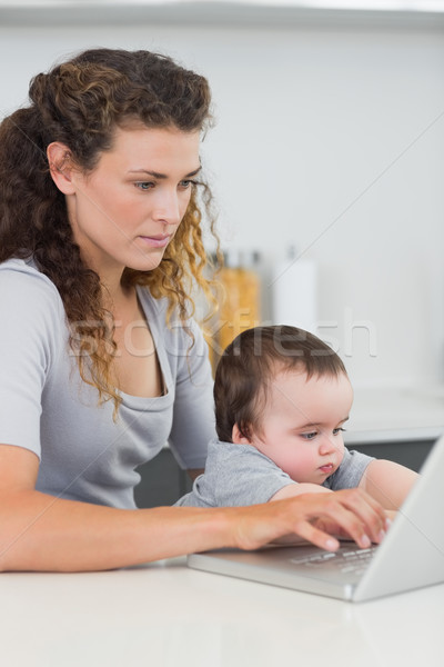 Nő baba laptopot használ pult koncentrált fiú Stock fotó © wavebreak_media