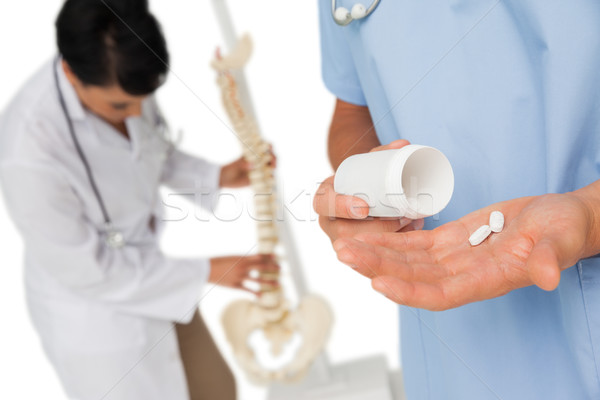 Mid section of doctors with pills and skeleton model Stock photo © wavebreak_media