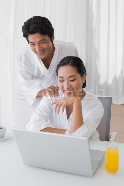 Couple in bathrobes using laptop together in the morning Stock photo © wavebreak_media