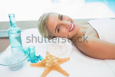 Stock photo: Beautiful woman lying on massage table at spa center