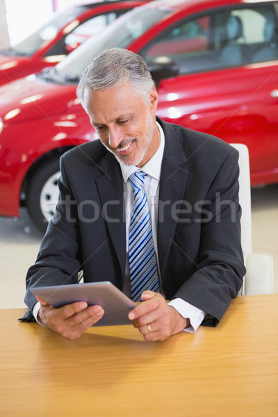 Smiling businessman using tablet at his desk Stock photo © wavebreak_media