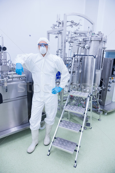 Scientist in protective suit leaning against machine Stock photo © wavebreak_media