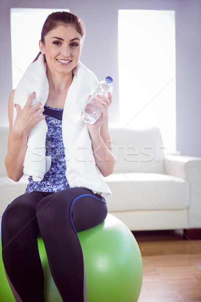 S'adapter femme serviette une bouteille d'eau maison salon [[stock_photo]] © wavebreak_media