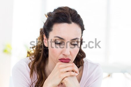 Upset brunette sitting on the couch Stock photo © wavebreak_media