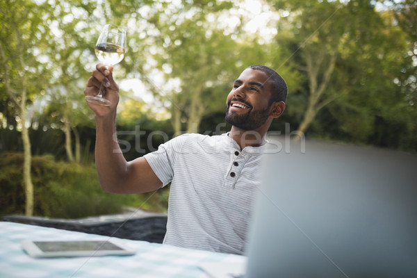 Stock photo: Smiling man holding wineglass while sitting at porch