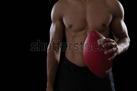 Muscular American football player holding a football in his hand Stock photo © wavebreak_media