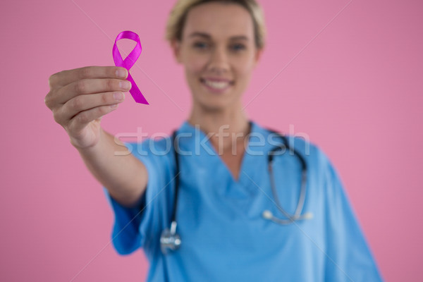 Portrait of female doctor in scrubs showing Breast Cancer Awareness ribbon Stock photo © wavebreak_media
