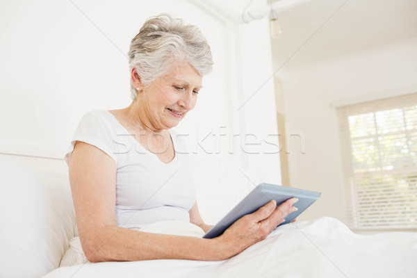Mujer sonriente tableta sesión cama mujer feliz Foto stock © wavebreak_media