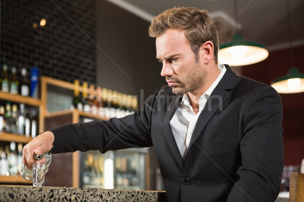 Tired man pouring a shot of alcohol Stock photo © wavebreak_media