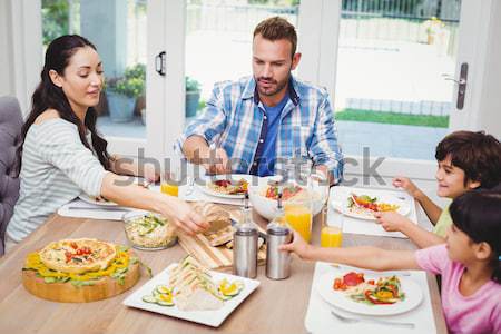 Woman serving food to friends  Stock photo © wavebreak_media