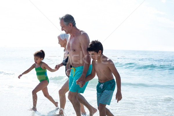 Stock photo: Grandchildren walking with grandparents at beach 