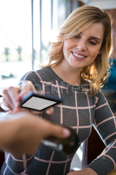Woman making payment through smartphone Stock photo © wavebreak_media
