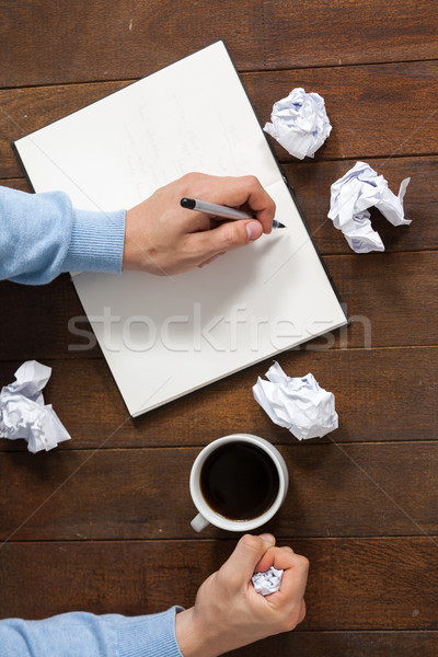 Man crumpling paper while writing on notepad Stock photo © wavebreak_media