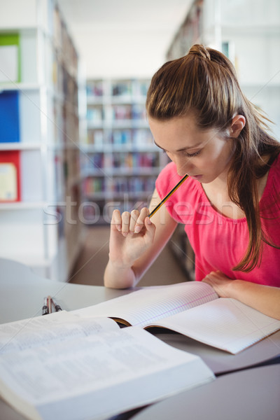 Schoolgirl doing homework in in library at school Stock photo © wavebreak_media