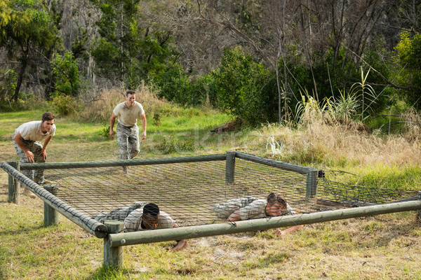 Soldiers crawling under the net during obstacle course Stock photo © wavebreak_media
