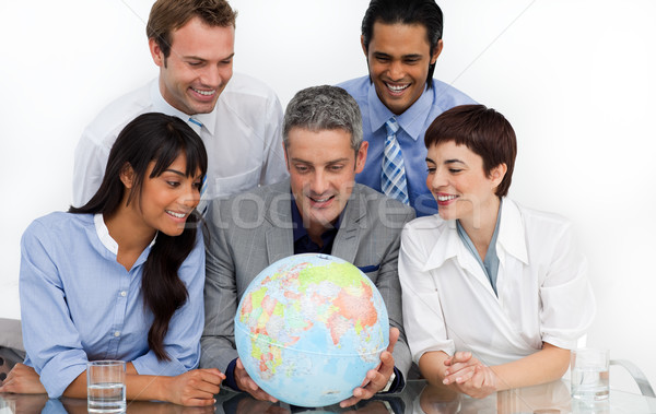 Smiling business people looking at a terrestrial globe  Stock photo © wavebreak_media