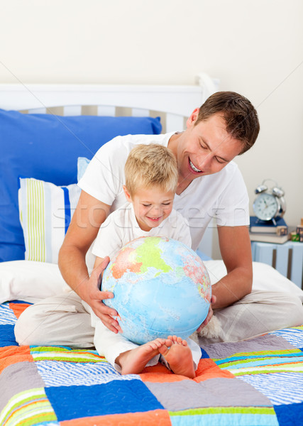 Laughing father and his son looking at a terrestrial globe Stock photo © wavebreak_media