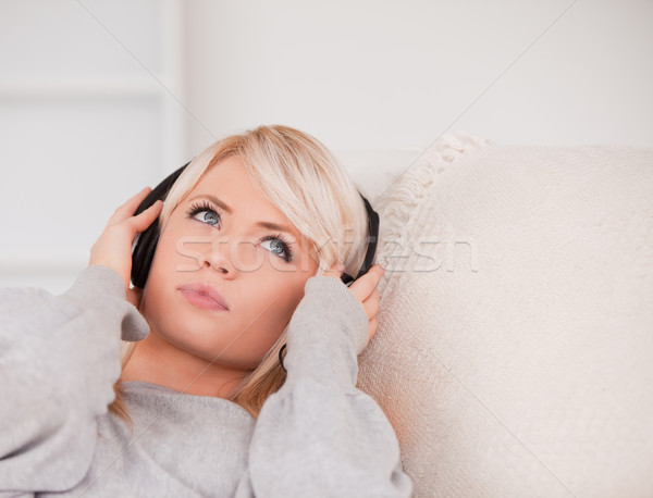 Vonzó fiatal szőke nő fejhallgató kanapé Stock fotó © wavebreak_media