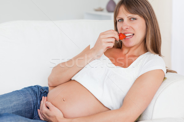 Femeie gravida mananca căpşune canapea zâmbet Imagine de stoc © wavebreak_media