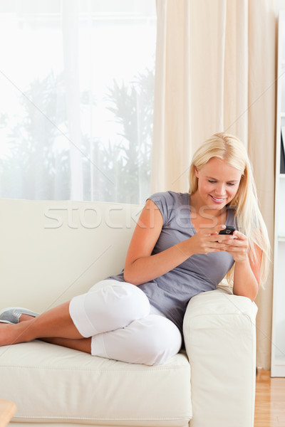 Portrait of a woman sending text messages in her living room Stock photo © wavebreak_media