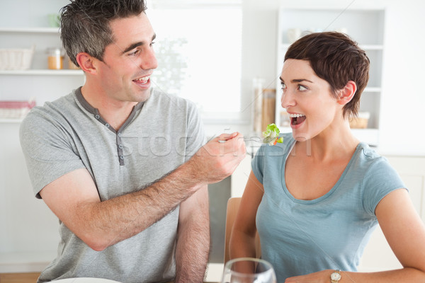 Man feeding his cute wife in a dining room Stock photo © wavebreak_media