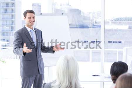 Smiling businessman greeting negotiation partner sitting behind a table Stock photo © wavebreak_media