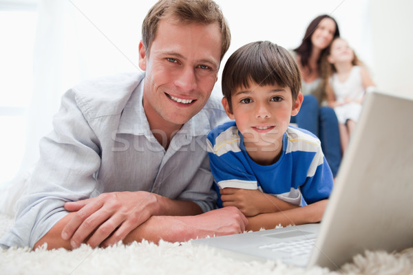 Boy with his father using laptop together on the carpet Stock photo © wavebreak_media