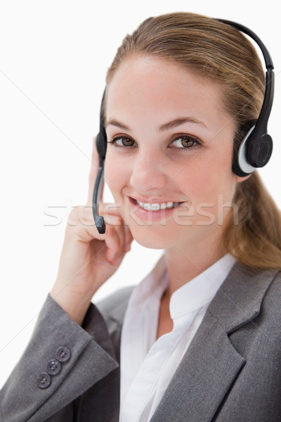 Stock photo: Side view of smiling female call center agent against a white background