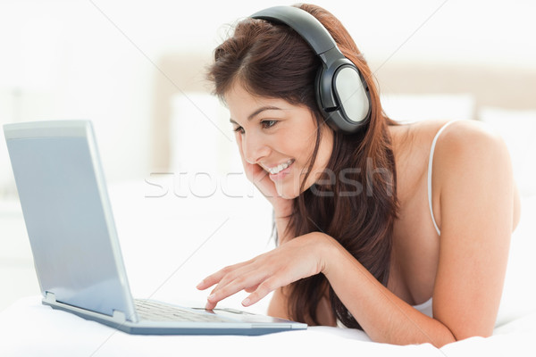 Uśmiechnięta kobieta słuchawki myszą laptop relaks Zdjęcia stock © wavebreak_media