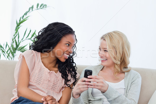 женщину сидят диване мобильного телефона улыбаясь Сток-фото © wavebreak_media