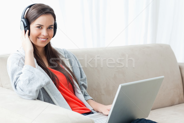 Stock foto: Lächelnde · Frau · Kopfhörer · Laptop · Aussehen · Kamera · glücklich