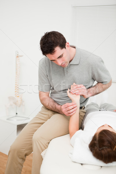 Serious physiotherapist moving the wrist of a woman in a medical room Stock photo © wavebreak_media