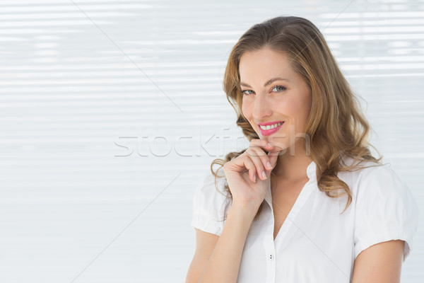 Smiling young businesswoman against blinds Stock photo © wavebreak_media