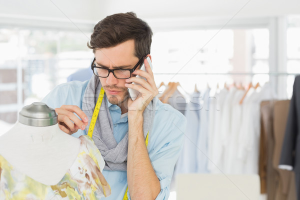 Fashion designer working on dress while using mobile phone Stock photo © wavebreak_media