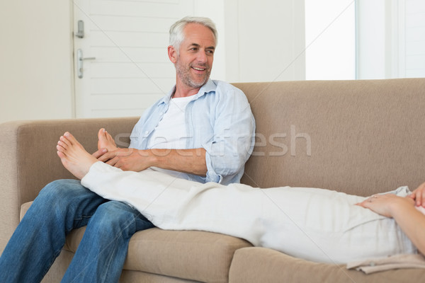 Caring man giving his partner a foot rub on the couch Stock photo © wavebreak_media