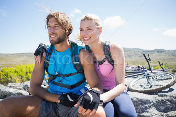 Fit cyclist couple taking a break on rocky peak  Stock photo © wavebreak_media