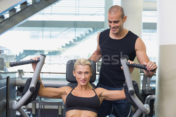 Entraîneur femme fitness machine gymnase souriant [[stock_photo]] © wavebreak_media