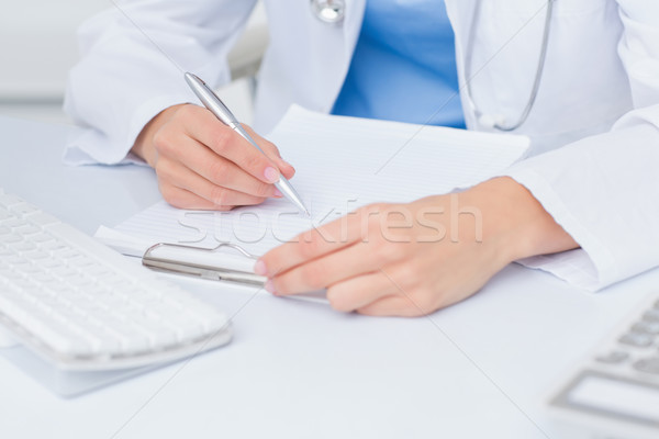 Female doctor writing prescriptions at table Stock photo © wavebreak_media