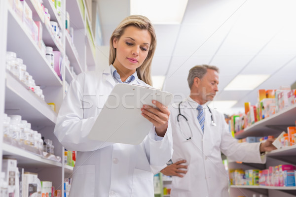 Young trainee writing on a prescription pad Stock photo © wavebreak_media