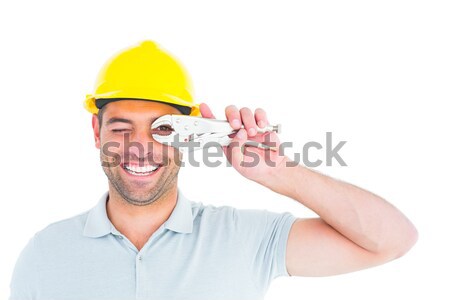 Cheerful handyman looking through pliers Stock photo © wavebreak_media