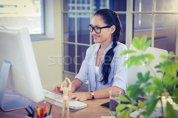 Stock photo: Happy young designer working at desk