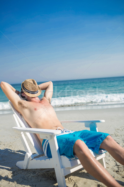 Man relaxing on deck chair at the beach Stock photo © wavebreak_media