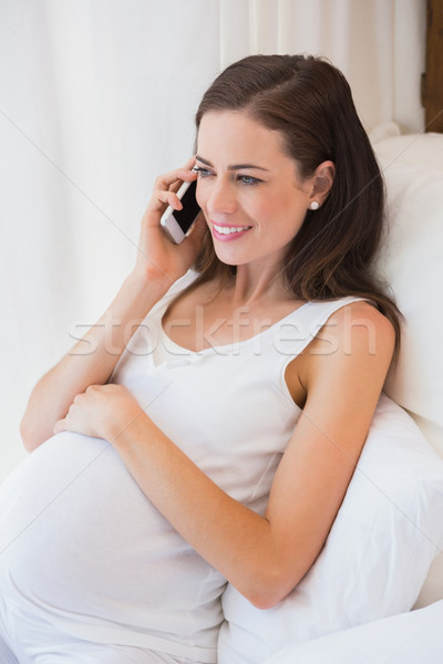 Sorridente gravidez cama casa quarto mulher Foto stock © wavebreak_media