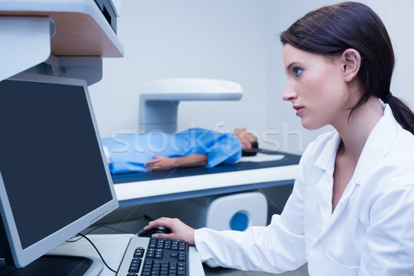 Doctor looking her computer while proceeding a radiography Stock photo © wavebreak_media