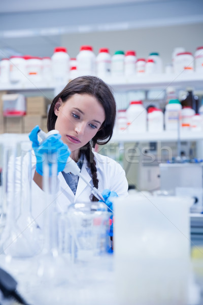 Concentrated female scientist using a pipette Stock photo © wavebreak_media