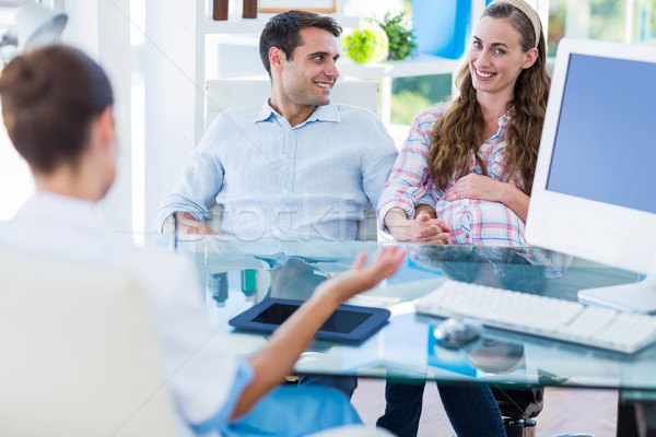 Stock photo: Pregnant woman with her husband smiling at camera
