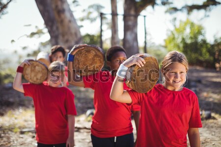 Stock photo: Group of women carrying a heavy wooden log during obstacle course