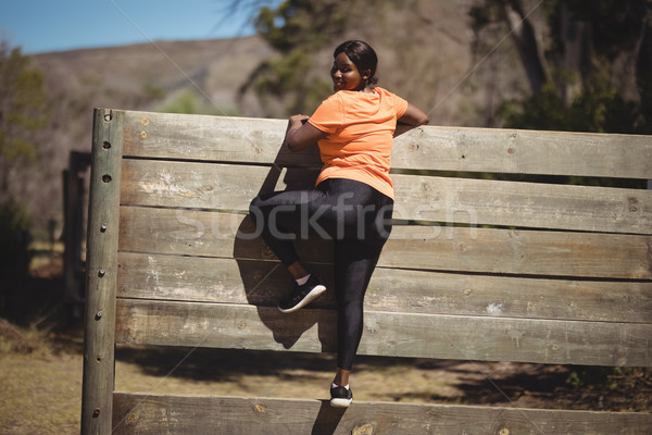 Portrait of woman climbing wooden wall during obstacle course Stock photo © wavebreak_media