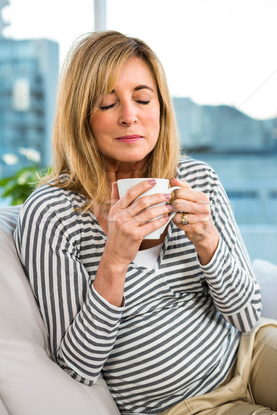 Stock photo: Woman holding cup on sofa