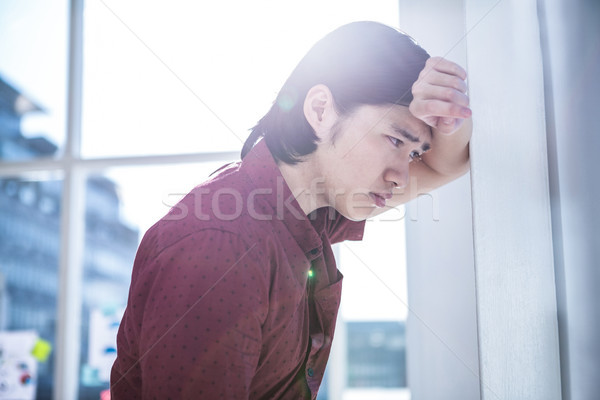 Worried creative businessman leaning on wall Stock photo © wavebreak_media